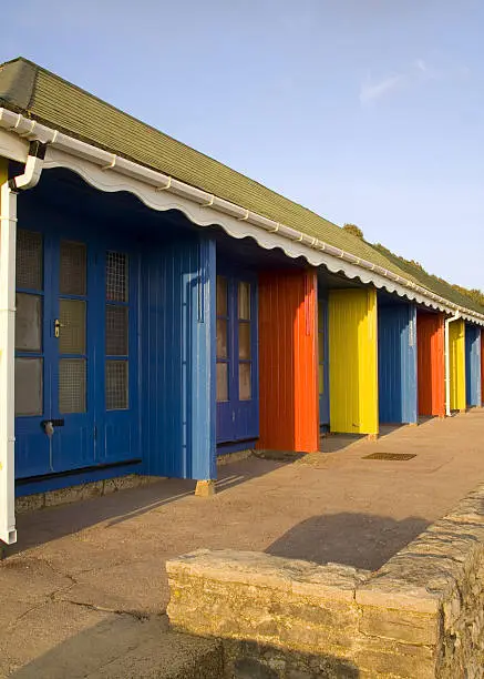 Blue, red and yellow beachhuts next to the beach promenade at Bournemouth