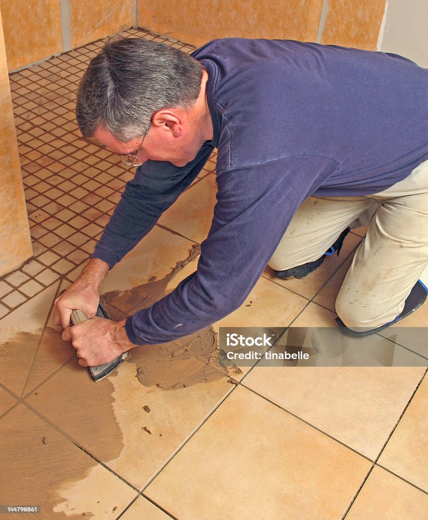 Uomo grouting piastrelle di ceramica - Foto stock royalty-free di Bagno domestico