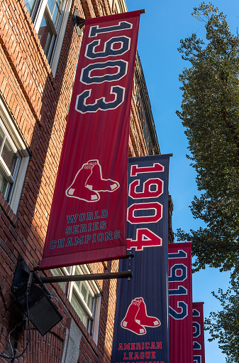 Boston, MA, USA - Nov 24, 2022:  Banners of the championships won by the Red Sox in the World Series, outside Fenway Park, in Boston. Fenway Park is a baseball stadium located in Boston, Massachusetts, United States. Since 1912, it has been the home of the Boston Red Sox, the city's American League baseball team, and since 1953, its only Major League Baseball (MLB) franchise.