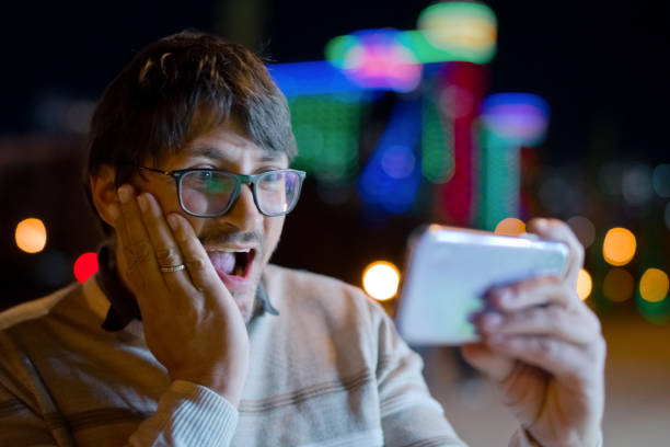 Man is excited about what he sees in his smart phone