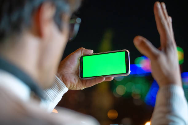 istock Excited man holding smartphone outdoors in night city 1447991069