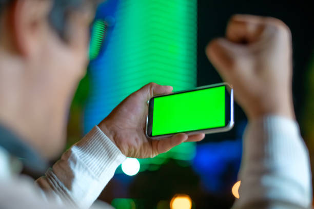 istock Excited man holding smartphone outdoors in night city 1447991119
