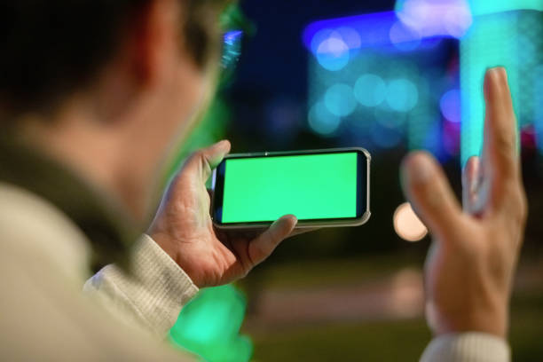 istock Excited man holding smartphone outdoors in night city 1447991248