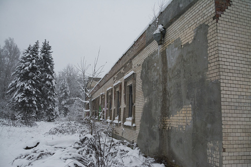 an old abandoned building in winter in the woods
