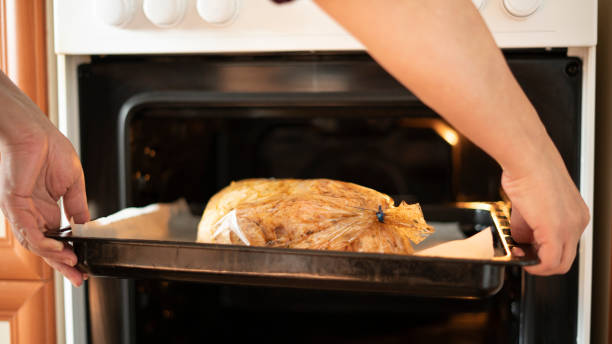 istock Chicken goes into the oven to cook 1447993740