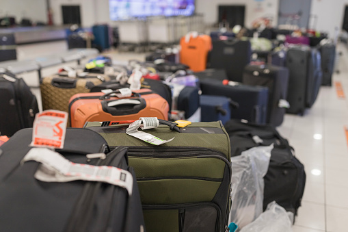 Briefcases waiting on a luggage rack for the travelers to pick them up