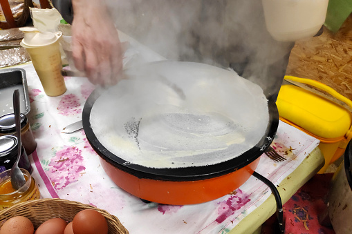 Making a crepe on a billig (crepe maker) on a fall evening in Brittany.