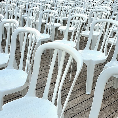 Large group of white plastic empty chairs