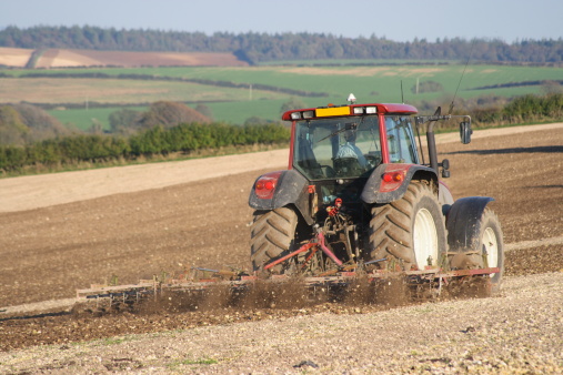 Tractor working on a field preparing the soil for planting.