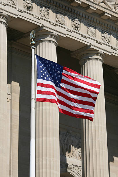 istock US flag pole in front of court pillars 144800346