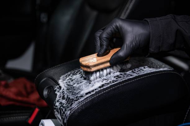 istock Car detailing or car wash studio worker cleans black leather car upholstery 1448003593