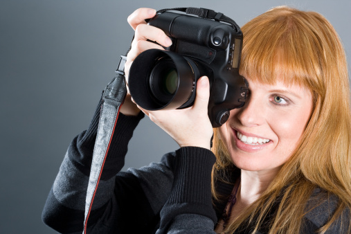 Nice woman taking pictures with professional camera.