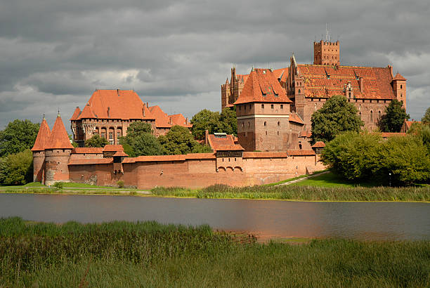 Highlighted Malbork castle Malbork castle from opposite river bank eventually highlighted with the sun marienburg stock pictures, royalty-free photos & images