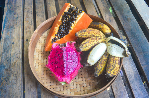 istock Tropical fruit arranged on a bamboo basket. The composition consists of papaya fruit, dragon fruit and banana. 1448008545