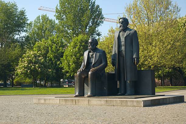 Marx & Engels Old statue in Alexanderplatz from the days of communism. Marx seated, Engels standing. friedrich engels stock pictures, royalty-free photos & images