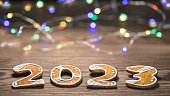 Beautiful New Year card for happy 2023 from ornate gingerbread numerals and LED light strings