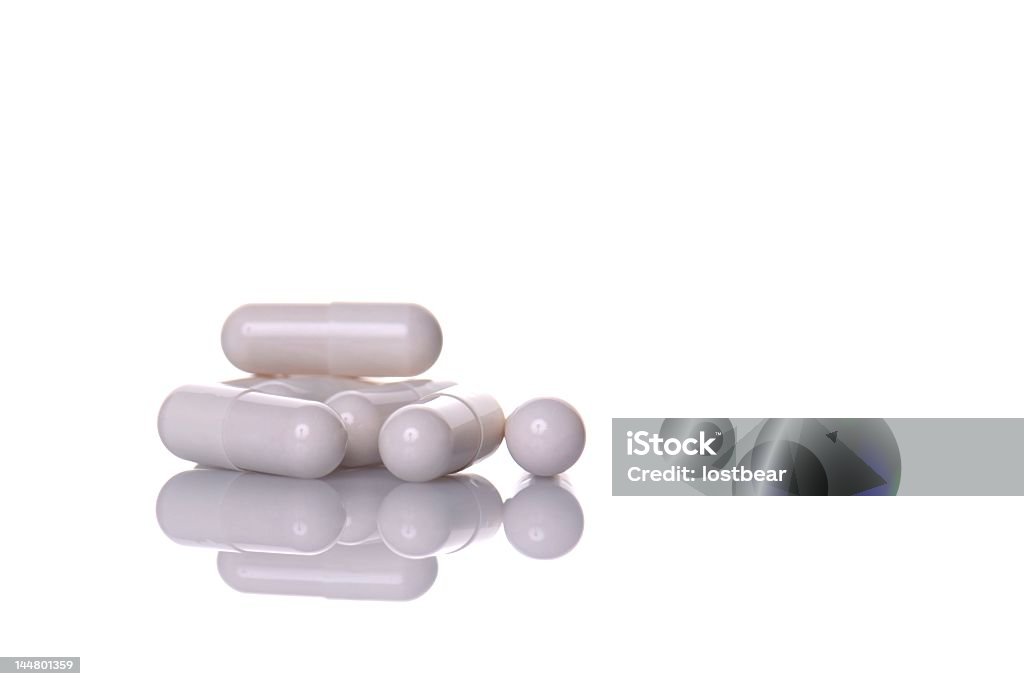 A pile of white pill capsules in white background Bunch of pills isolated on white background Addiction Stock Photo