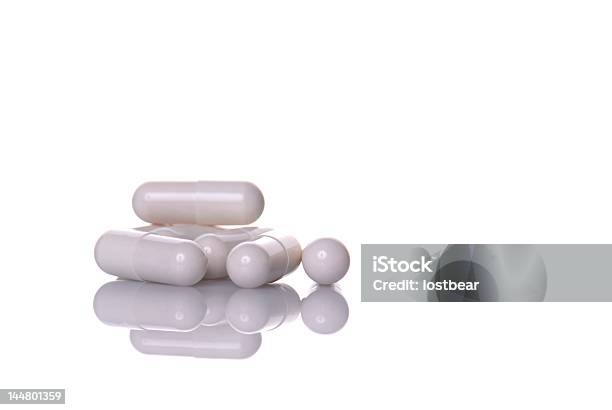 A Pile Of White Pill Capsules In White Background Stock Photo - Download Image Now - Addiction, Antibiotic, Capsule - Medicine