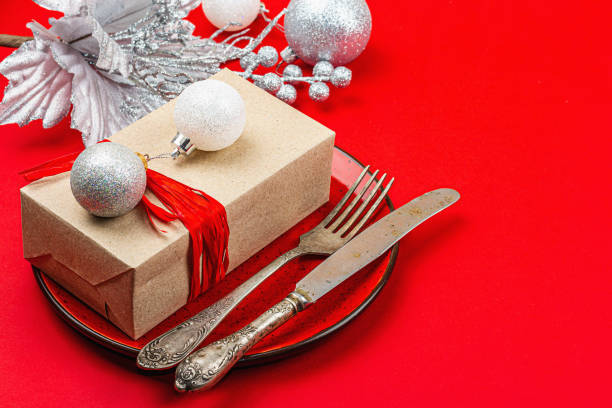 istock Christmas table setting with a festive gift box in red and silver colors. New Year background 1448014071