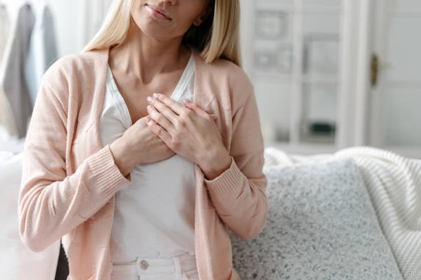 istock Woman holding folded hands on chest, feeling deeply thankful 1448015714