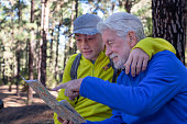 istock Young grandson and old grandfather consulting trail map while hiking in mountain forest enjoying nature and healthy activity. The new and old generation share the same passion. Adventure has no age 1448016624