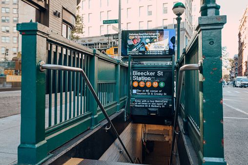 New York, USA - November 21, 2022: Entrance and stairs down to Bleecker Street subway station in New York, USA. New York City Subway is one of the world's oldest public transit systems.