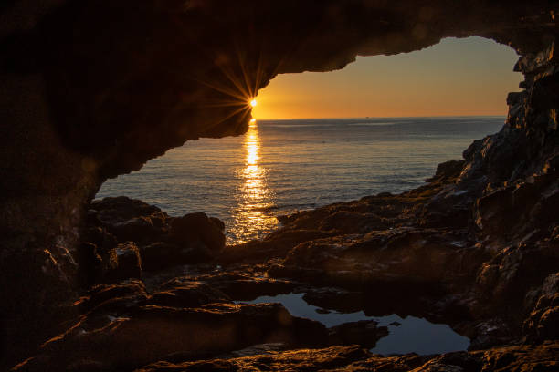 istock Sunrise over the Atlantic Ocean, reflected in a sea cave pool 1448021139