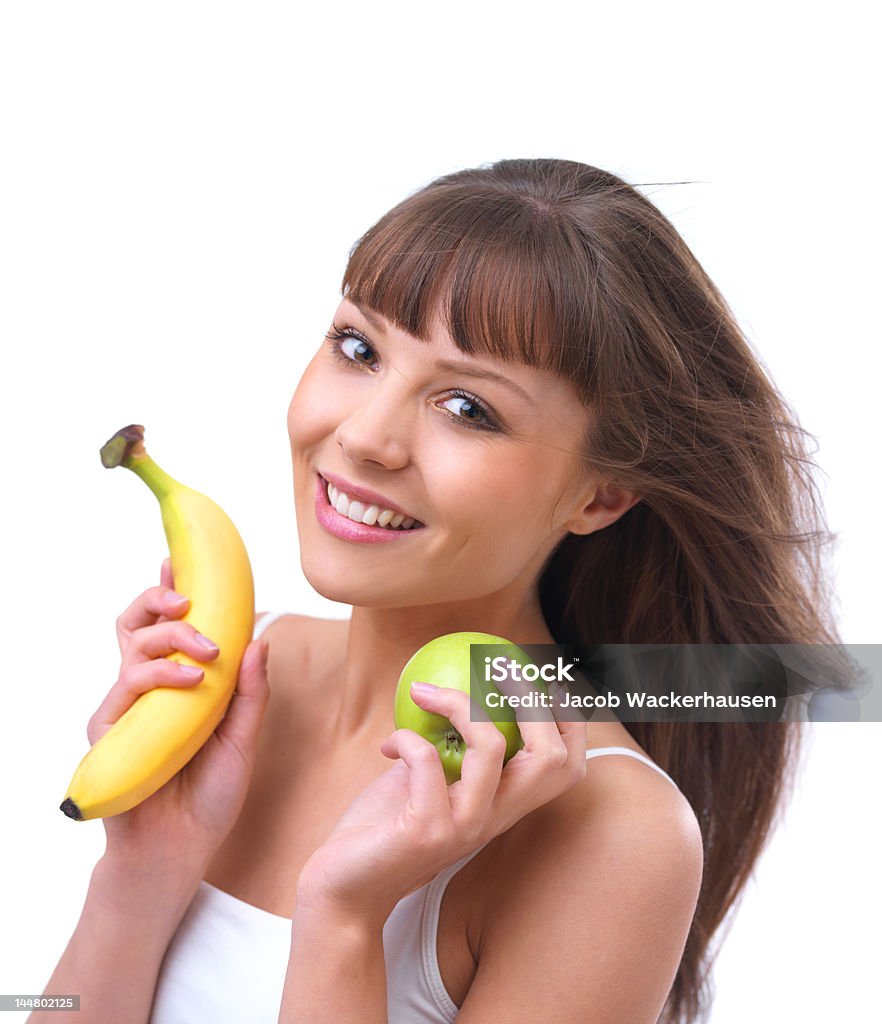 Superbe jeune femme tenant une pomme ou une banane - Photo de 20-24 ans libre de droits
