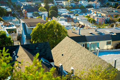 Double gable style rooftops with dark tiles as seen from suburban look out point with sprawling cityscapes in neighborhoods. In the historic districts of san francisco california in the downtown.