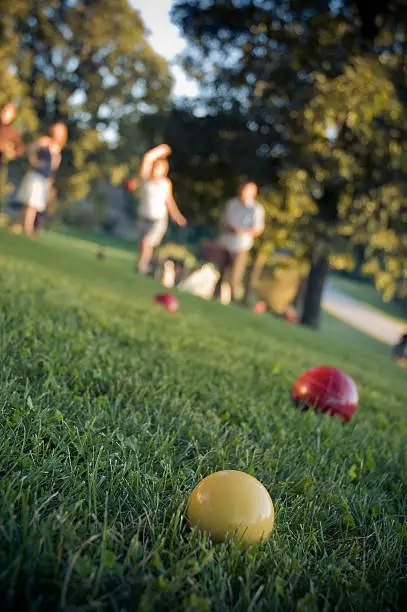 Young people playing lawn bowling (bocce ball).