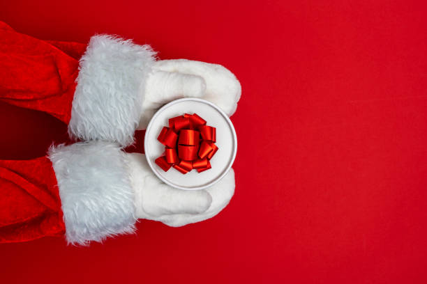 istock Santa's hands are holding a gift for Christmas. red background 1448025358