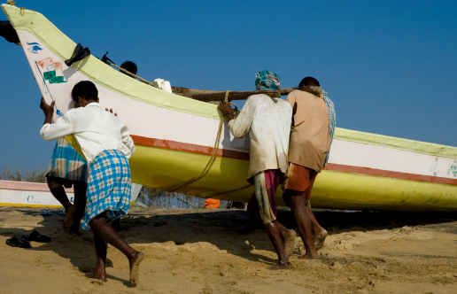 Trincomalee, North Western Province, Sri Lanka - March 3rd 2023: Colorful small fiberglass fishing boat on the tropical beach