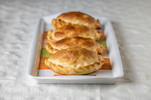 Argentinian empanadas baked on a platter.