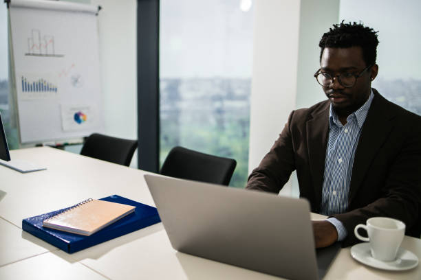 istock Young businessman using a laptop in a modern office 1448027496
