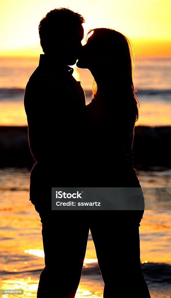 Silhouette von einem jungen Paar Küssen am Strand - Lizenzfrei Berühren Stock-Foto