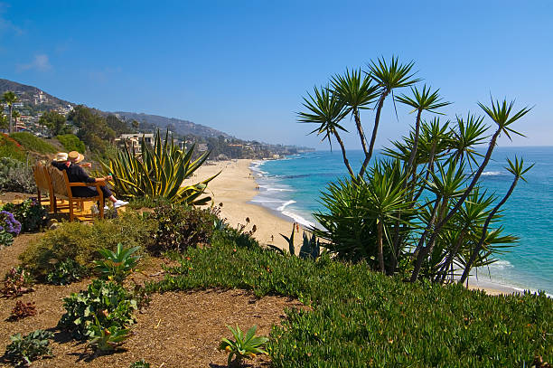 Friends sitting on a bench overlooking the ocean stock photo