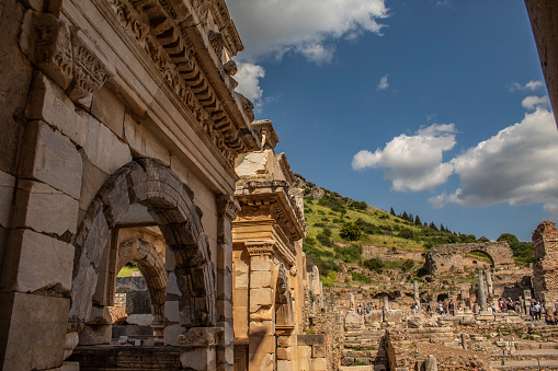 Ruins, trees, mountain and cloudy sky in the ancient city of Ephesus