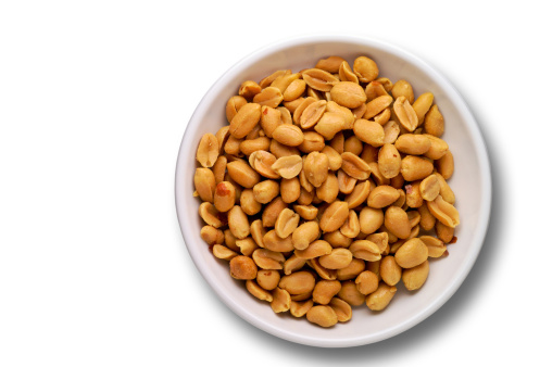 Peanuts in a dish from above over white with clipping path