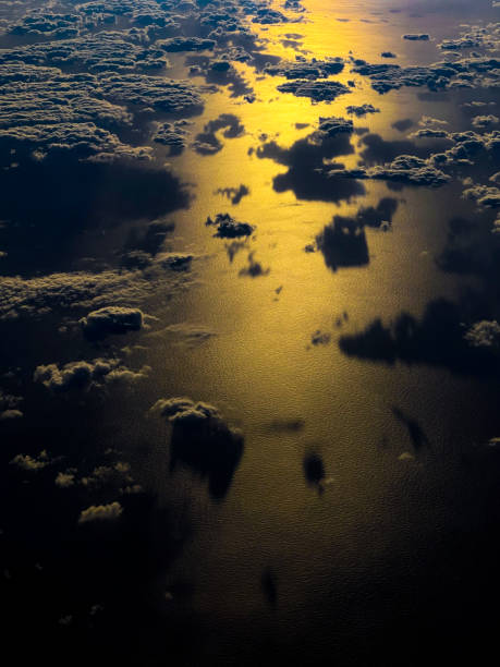 istock Airplane window view of clouds and ocean at sunset 1448029706