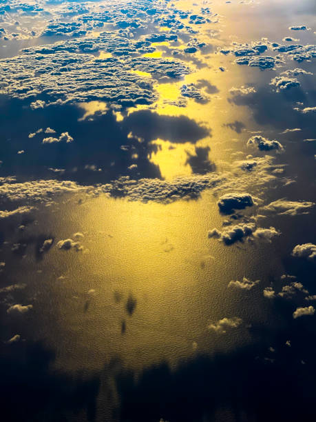 istock Airplane window view of clouds and ocean at sunset 1448029707