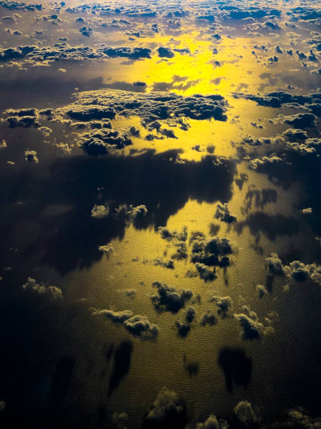 istock Airplane window view of clouds and ocean at sunset 1448029722