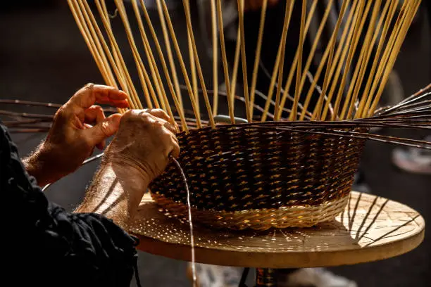 an artisan making a basket in the image