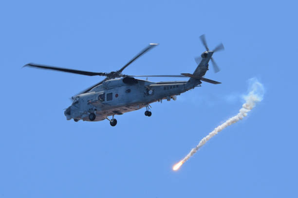 Japan Maritime Self-Defense Force Sikorsky SH-60K Seahawk anti-submarine helicopter deploying IR flare. Kyoto Prefecture, Japan - July 25, 2014: Japan Maritime Self-Defense Force Sikorsky SH-60K Seahawk anti-submarine helicopter deploying IR flare. blackhawk stock pictures, royalty-free photos & images