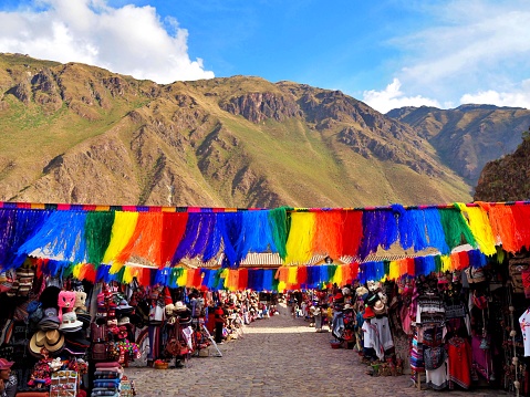 rainbow flags hanging in a market in Ollantaytambo