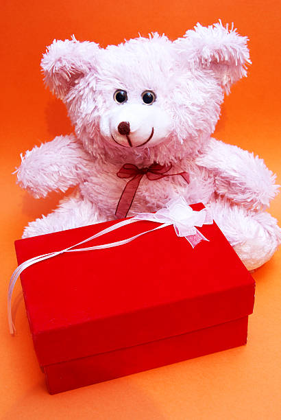 istock Pink fluffy bear sitting by a red box 144803431