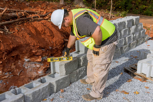 istock Contractor during the installation of a new large block retaining wall in construction site 1448035045