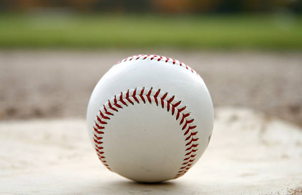 istock baseball on homeplate with green field 144803832