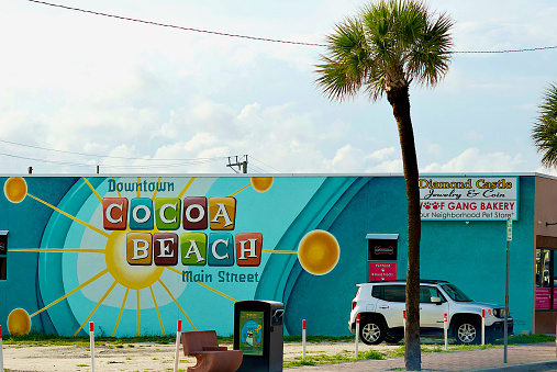 Cocoa Beach, Florida, USA - June 1, 2020:  The side of a small business in downtown Cocoa Beach is adorned with a mural celebrating “Downtown Cocoa Beach Main Street” on a hot, stormy afternoon.