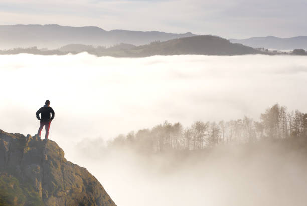 istock Hiker and sea of clouds with mountains in the background 1448043151