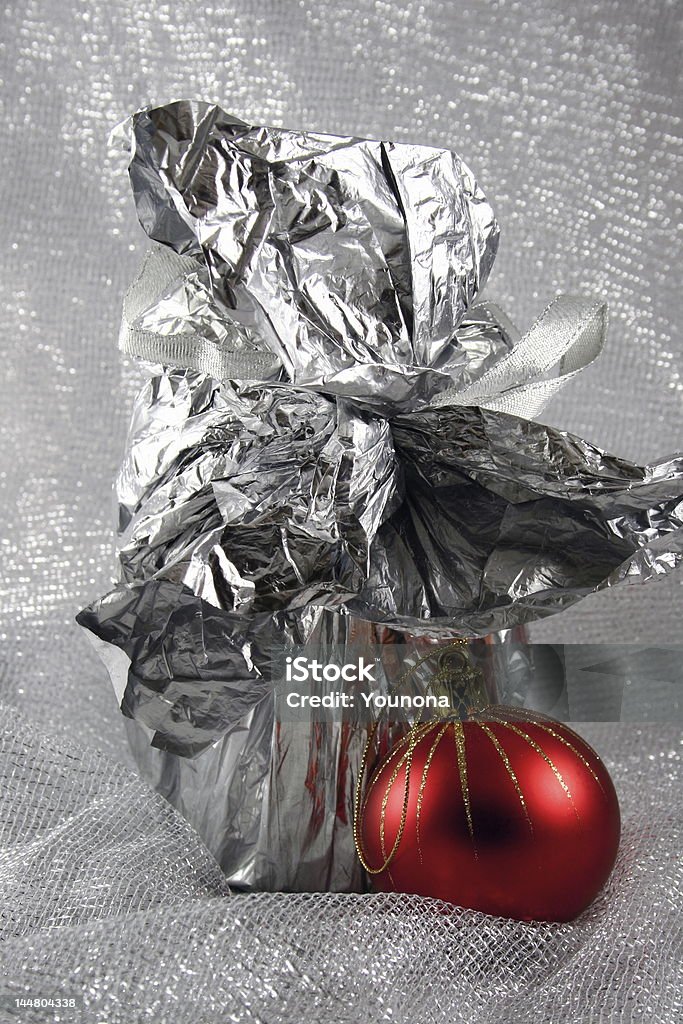 Palla di Natale accanto a un regalo - Foto stock royalty-free di Argentato